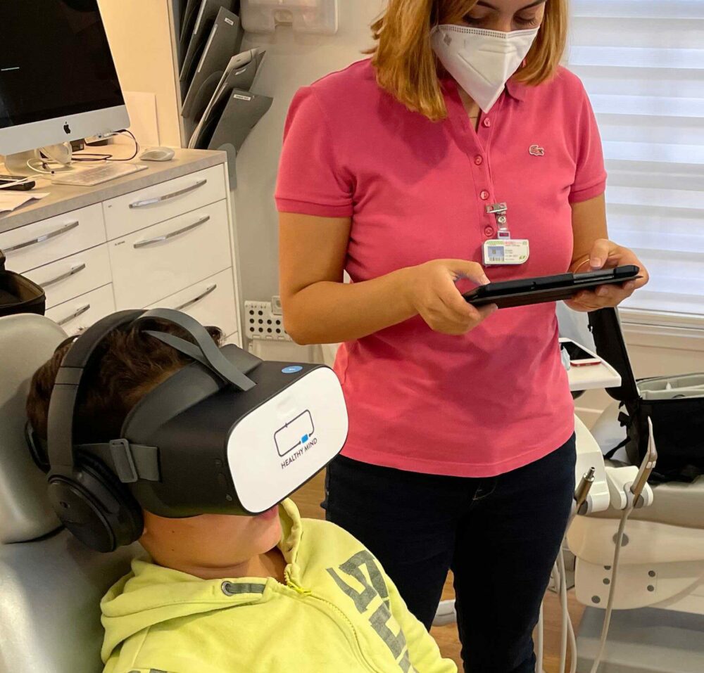 Dentist using a virtual reality headset to reduce a child's stress