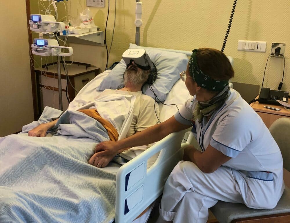 Patient accompagné d'un soignant utilisant un casque de réalité virtuelle en soins palliatifs pour diminuer le stress